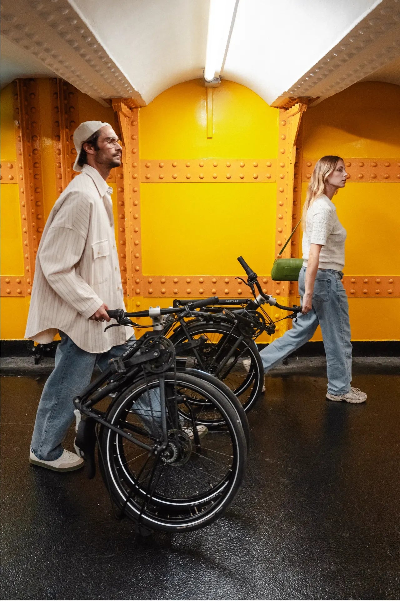 Un couple avec chacun un vélo Bastille plié dans le métro