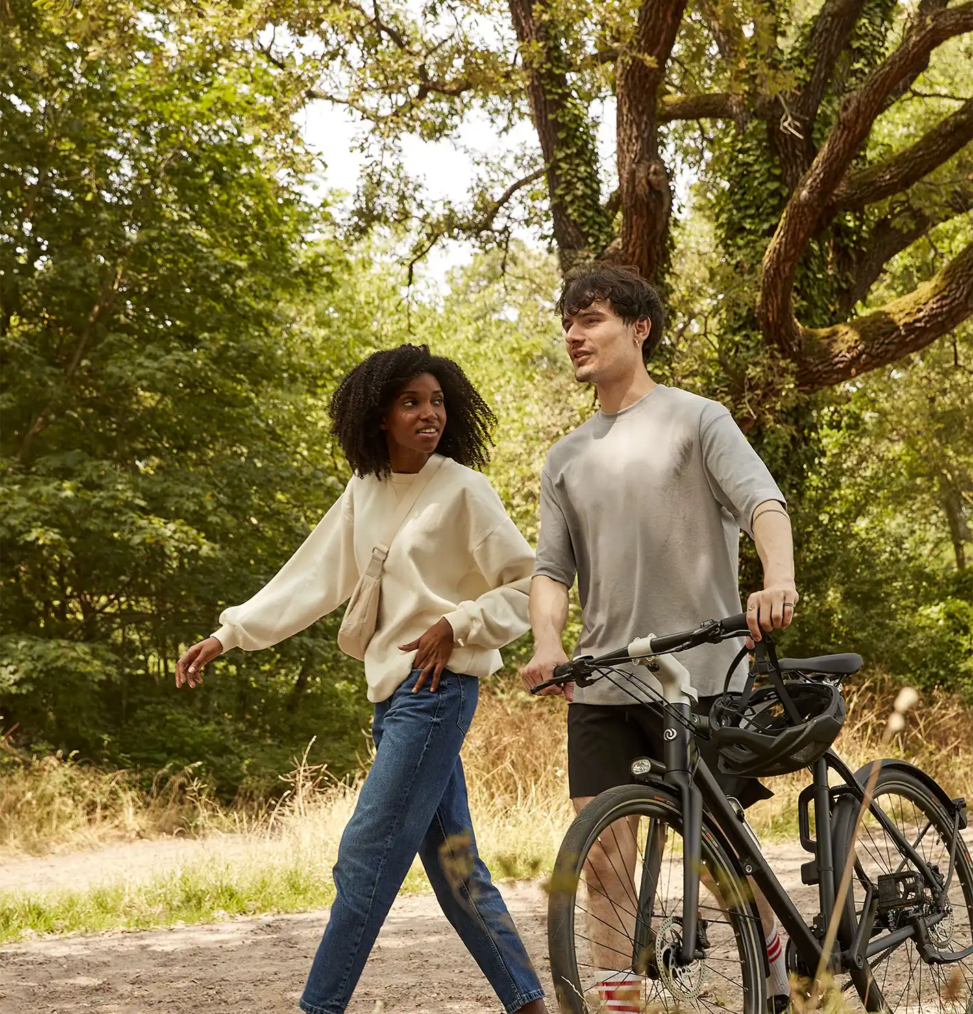 2 amis marchant dans les bois, l'un en tirant son vélo Bastille