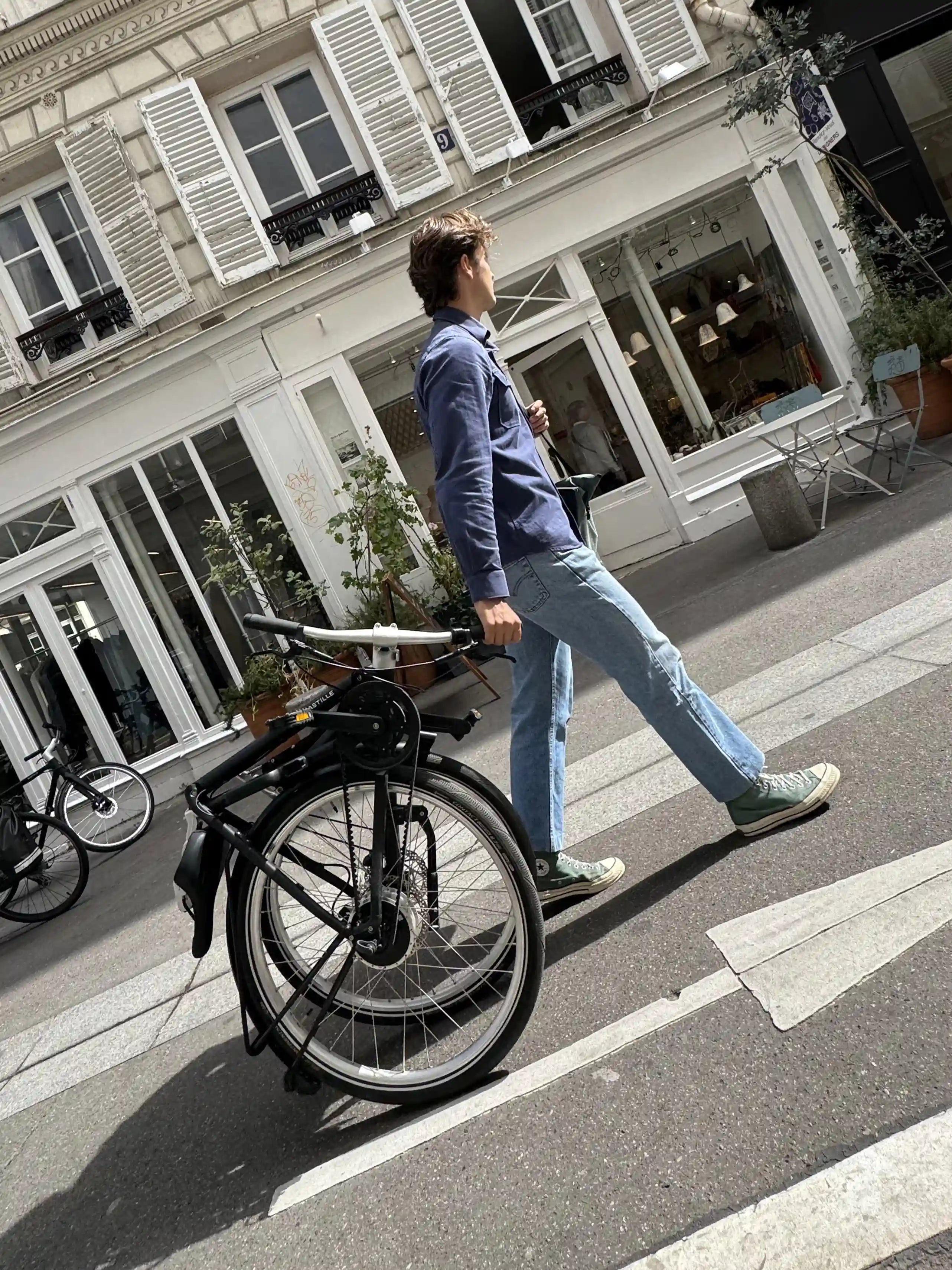 Un homme fait rouler son Bastille électrique plié derrière lui.