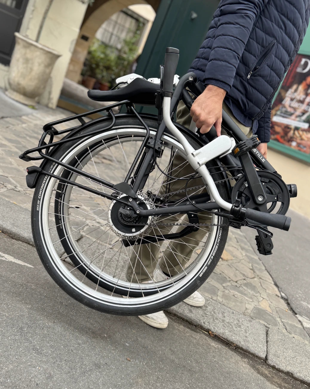 Un homme porte le bastille électrique plié.