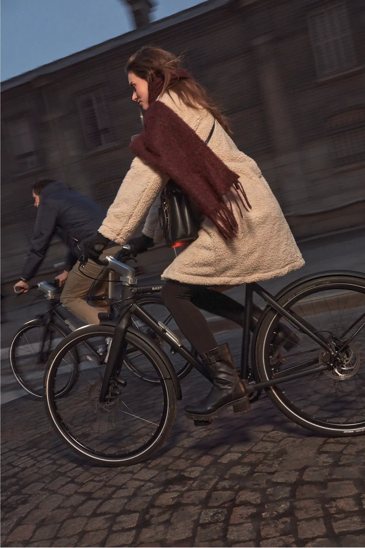 Une femme roule sur les pavés avec son vélo pliant à grandes roues